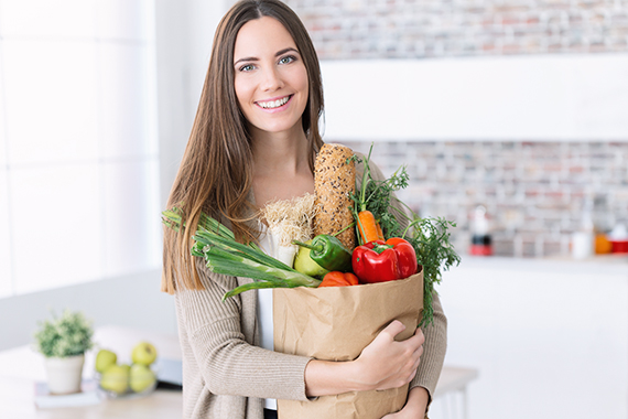 En kvinde med en pose fyldt med grøntsager