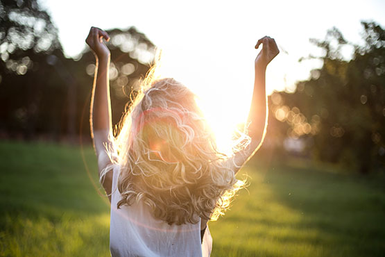 Woman looking at the sun, which provides vitamin d